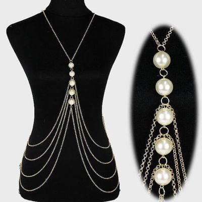 A display featuring the Elegant Pearl Cascade Body Chain, showcasing its intricate layers of gold chains and pearls on a black mannequin.