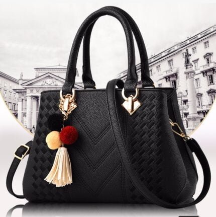 Black luxury handbag with gold-tone hardware and tassel charms, featuring a quilted design