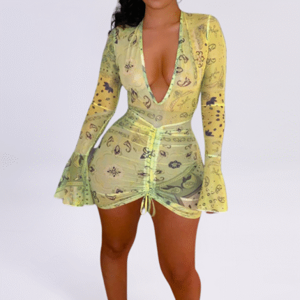 Model wearing a mint green paisley-printed ruched mini dress with a deep V-neckline and long bell sleeves.