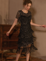 Woman wearing a vintage-inspired fringe and sequin midi dress in black-gold, standing in an elegant setting.