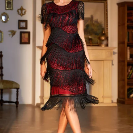 Woman wearing a vintage-inspired fringe and sequin midi dress in black-gold, standing in an elegant setting.