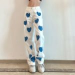 "Heart print wide-leg jeans in white denim with blue heart accents."