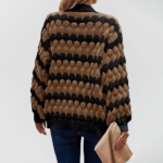 Oversized knit cardigan with textured bubble-knit pattern, styled with casual jeans.