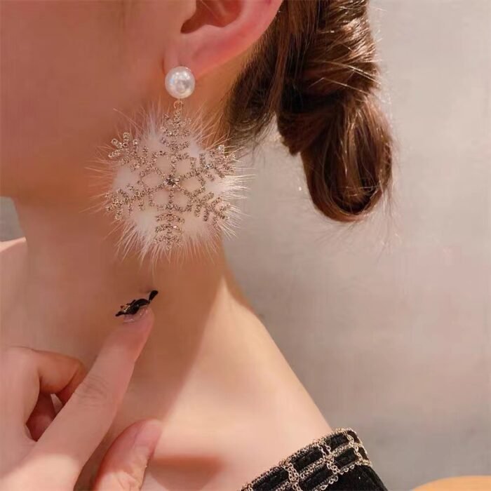 "Elegant snowflake drop earrings with rhinestones, faux fur, and pearl studs."