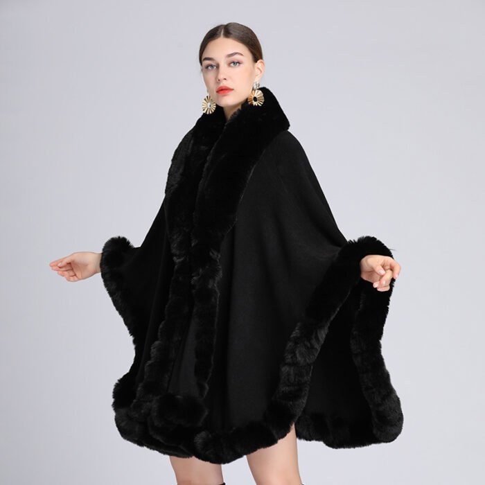 Woman wearing a luxurious imitation cashmere batwing cardigan with fur trim in dark blue.