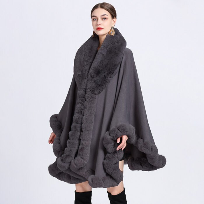 Woman wearing a luxurious imitation cashmere batwing cardigan with fur trim in dark blue.