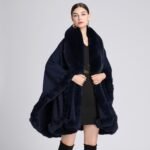 Woman wearing a luxurious imitation cashmere batwing cardigan with fur trim in dark blue.