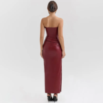 Bordeaux faux-leather bustier midi dress with sweetheart neckline and side slit, styled in a luxurious library setting