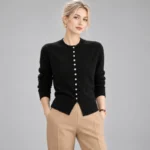 Black crew-neck button-down cardigan with long sleeves and ribbed hem, styled with beige trousers.