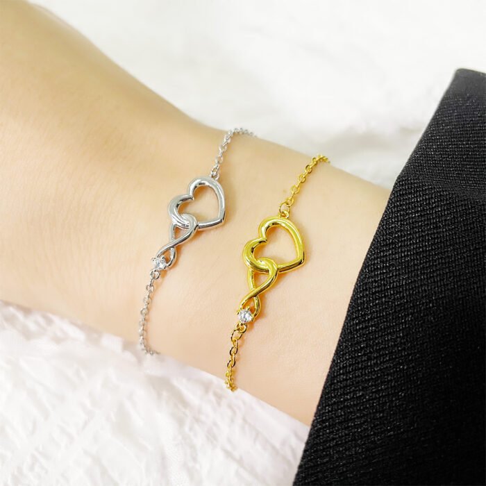 Close-up of the Infinity Heart Bracelet in gold and silver, elegantly displayed on a wrist.