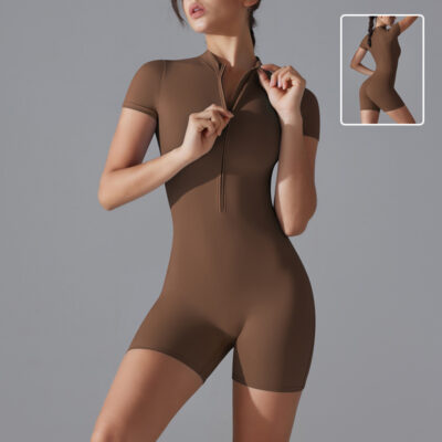 Model wearing a deep maroon zip-up active romper, showing a sculpted fit. Another model styled in a charcoal gray romper, posed for an athletic aesthetic.