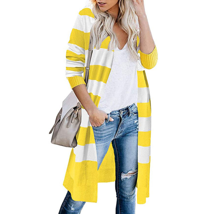 Model wearing a striped knit long cardigan in multiple colors, paired with jeans and a white top.