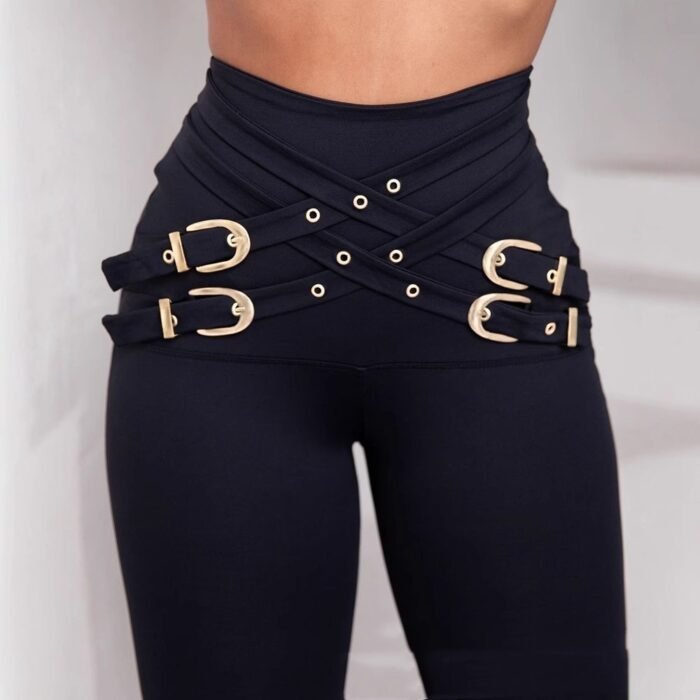 Model wearing high-waist black leggings with gold buckle detail and sculpting fit, paired with red heels.