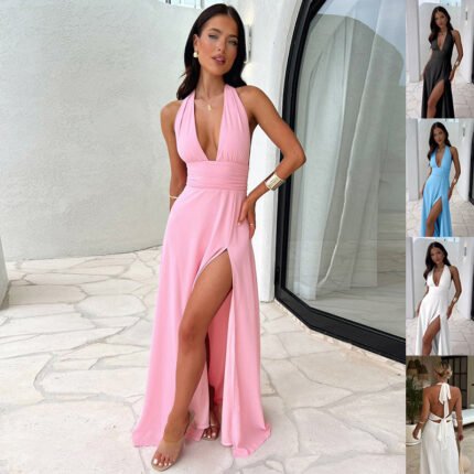 A model wearing the Evelyn Plunge Halter Maxi Dress in pink, featuring a deep V-neck, a cinched waist, and a high-slit flowing skirt