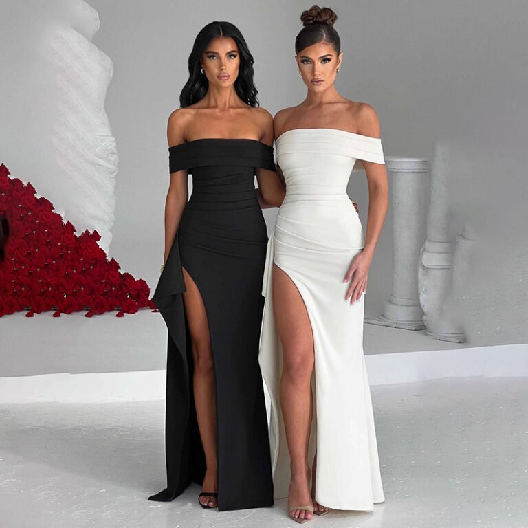 Model wearing off-shoulder high-slit gown in red, black, and white. Formal eveningwear dress with dramatic thigh-high slit and sculpted fit.
