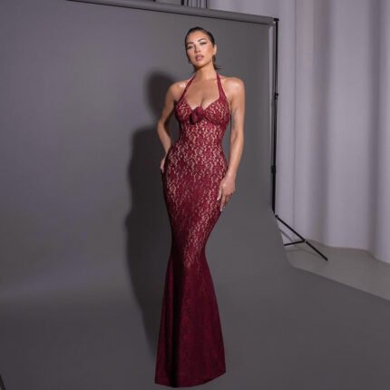 Woman in full-length garnet lace halter gown posing confidently