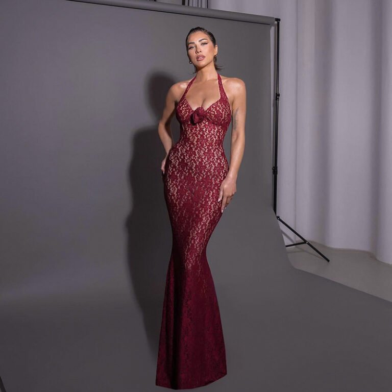 Woman in full-length garnet lace halter gown posing confidently