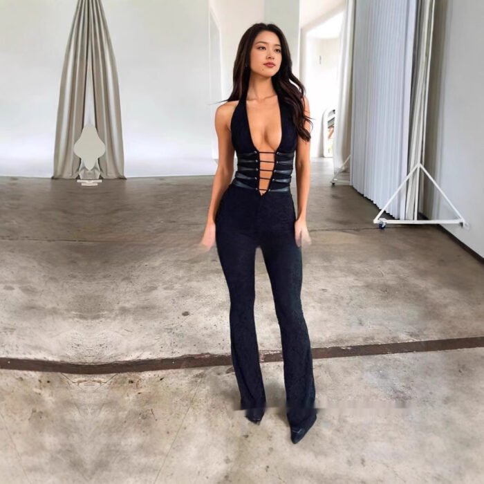 Woman wearing black cutout plunge halter jumpsuit in studio
