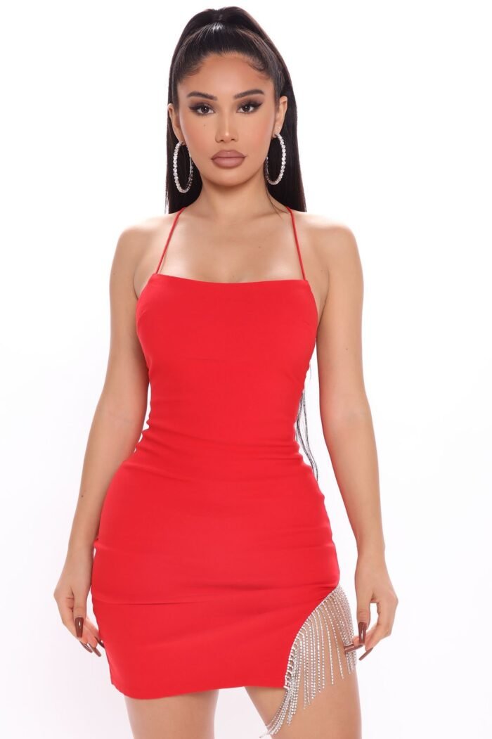 Woman in black rhinestone slit bodycon mini dress Back view of blush pink rhinestone slit dress Front view of red slit sparkle mini dress White sparkle mini dress with side rhinestone detail