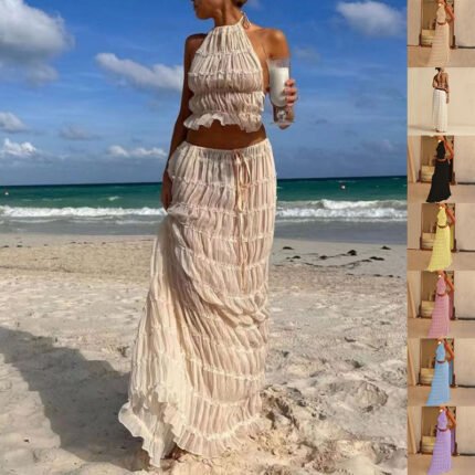 Woman in beige boho two-piece set with halter crop top and tiered maxi skirt on beach