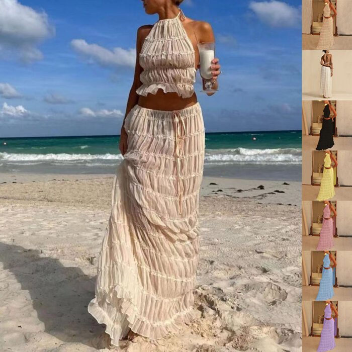 Woman in beige boho two-piece set with halter crop top and tiered maxi skirt on beach