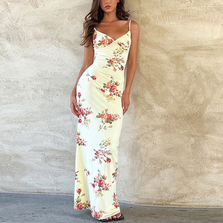 Woman in yellow floral maxi dress standing against beige textured wall