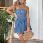 Woman wearing blue button-front mini dress with wicker bag Model in green summer mini dress in front of indoor plant Blush rose version of the dress styled with soft waves Charcoal black version styled for city chic