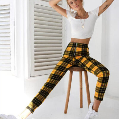 Models wearing plaid high-waisted pants in black and white checkered, red plaid, and yellow tartan prints, paired with white sneakers.