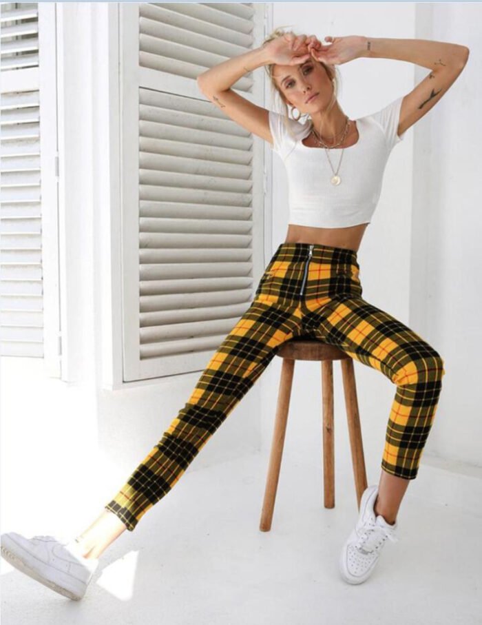 Models wearing plaid high-waisted pants in black and white checkered, red plaid, and yellow tartan prints, paired with white sneakers.