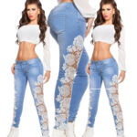 Model wearing light blue high-waisted skinny jeans with sheer white floral lace panels