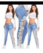 Model wearing light blue high-waisted skinny jeans with sheer white floral lace panels