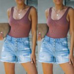 Model wearing high-rise distressed denim shorts with tank top