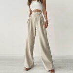 Woman wearing cream satin high waist wide-leg trousers with side ties