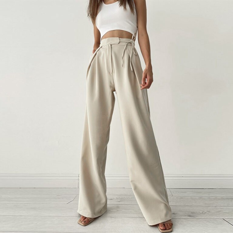 Woman wearing cream satin high waist wide-leg trousers with side ties