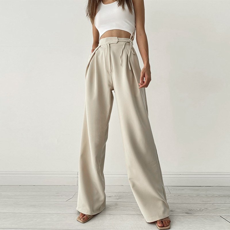 Woman wearing cream satin high waist wide-leg trousers with side ties