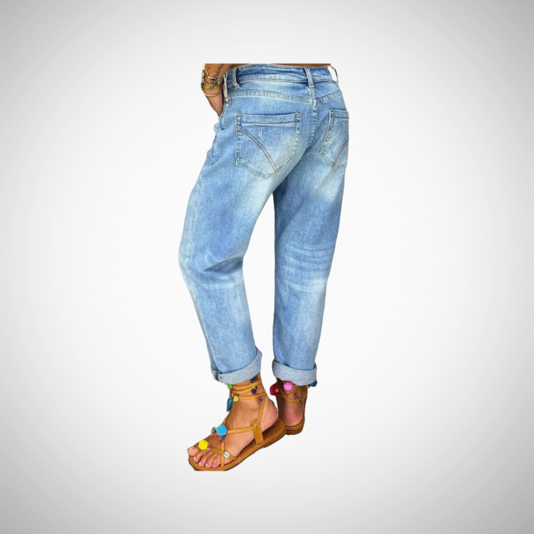 Woman wearing light blue distressed boyfriend jeans with rolled cuffs and button-fly closure