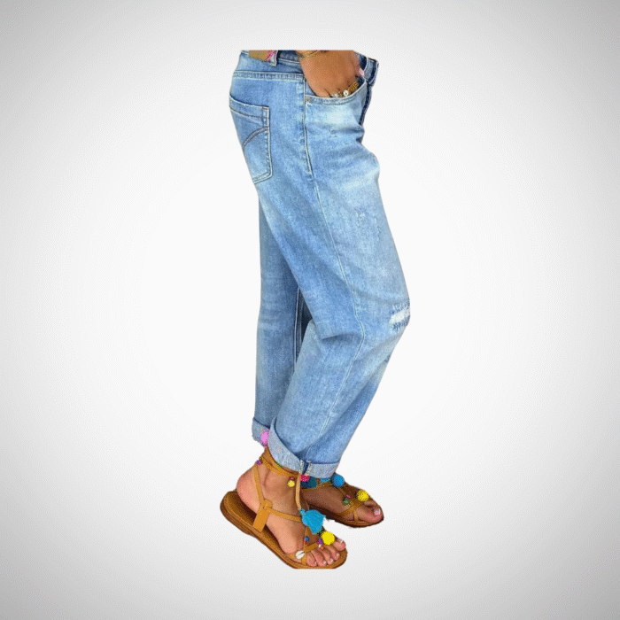 Woman wearing light blue distressed boyfriend jeans with rolled cuffs and button-fly closure