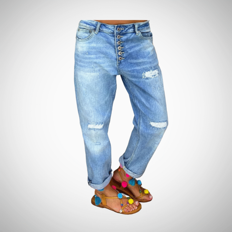 Woman wearing light blue distressed boyfriend jeans with rolled cuffs and button-fly closure
