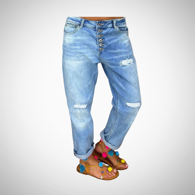 Woman wearing light blue distressed boyfriend jeans with rolled cuffs and button-fly closure