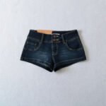 Model wearing ultra-short denim shorts and black tank top