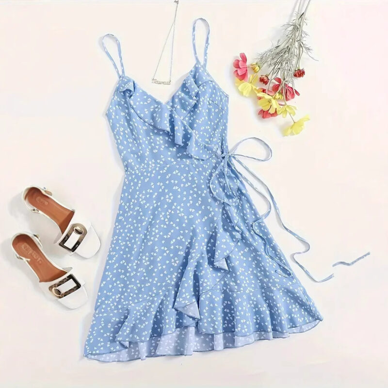 Flat-lay of light blue wrap dress with white heart prints and ruffles