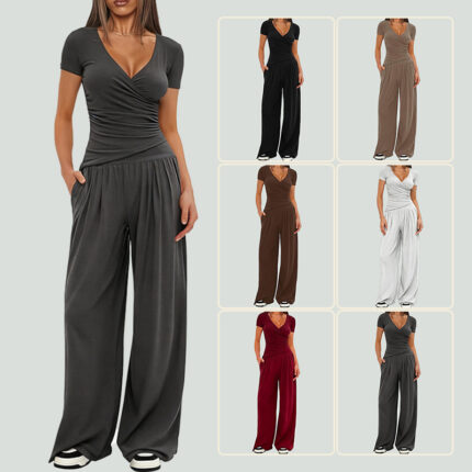 Model wearing a two-piece V-neck short sleeve top and wide-leg pants set in charcoal gray with additional color variations shown.