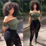 Model wearing high waist white and black extreme distressed skinny jeans with dramatic slashes, styled with heels and crop tops for an edgy streetwear look.