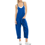 Relaxed fit sleeveless jumpsuit with pockets in neutral tones, styled with sneakers for casual wear.