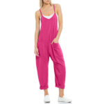 Relaxed fit sleeveless jumpsuit with pockets in neutral tones, styled with sneakers for casual wear.