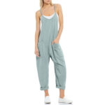 Relaxed fit sleeveless jumpsuit with pockets in neutral tones, styled with sneakers for casual wear.
