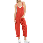 Relaxed fit sleeveless jumpsuit with pockets in neutral tones, styled with sneakers for casual wear.