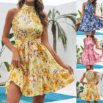 Woman wearing a pink floral halter mini dress with ruffle hem near a poolside setting.