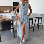 Woman wearing a sleeveless button-front denim maxi dress with a tie waist, utility pockets, front slit styling, and white sneakers, shown in light blue, medium blue, pink, and washed black.