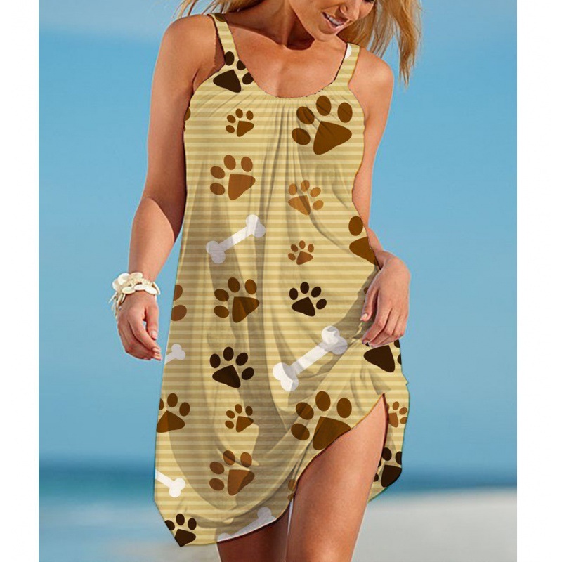 Woman wearing a sleeveless pet print beach slip dress with a scoop neckline, relaxed fit, and side slit, shown in multiple paw print, shell, bone, and dog-inspired designs.